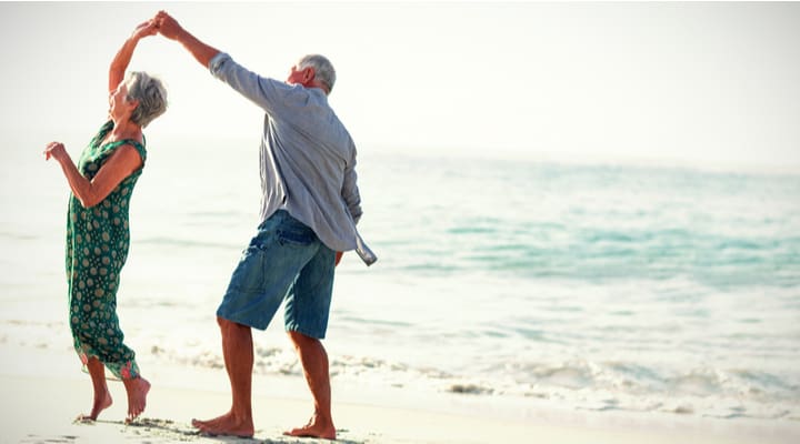 Retired couple dancing on a beach