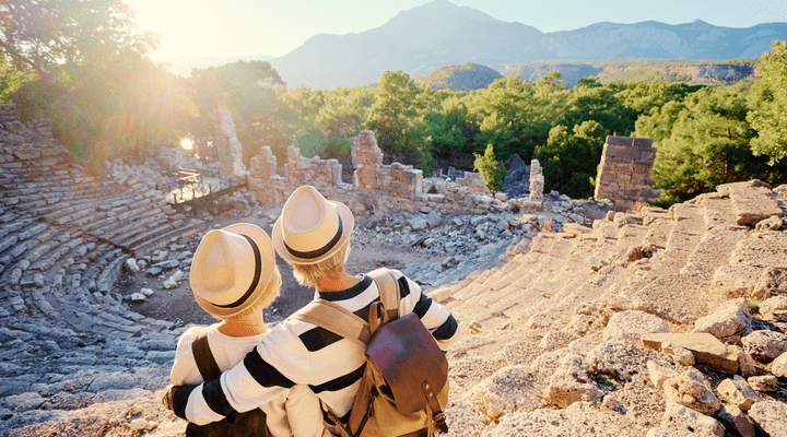 A mature couple enjoying the view of an ancient amphitheatre.