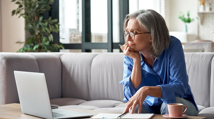 An older woman working on a laptop.