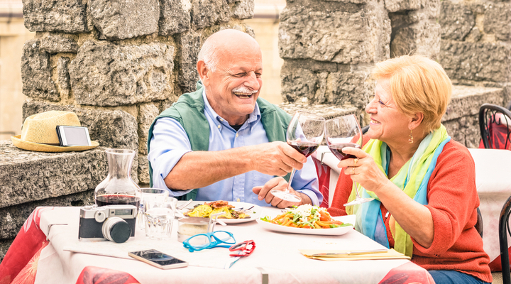 An older couple eating at a restaurant while on holiday.