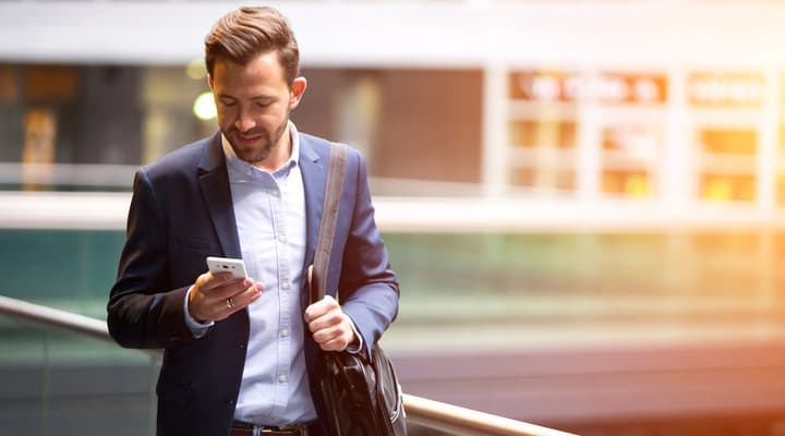 A man walking and using his smartphone.