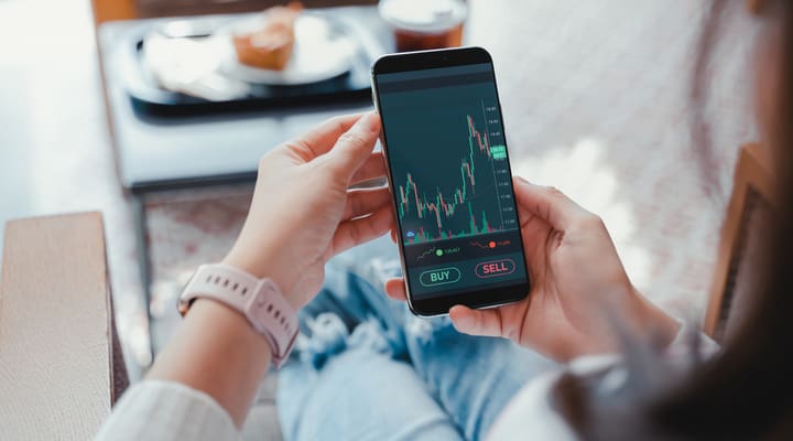 A woman looking at investment performance on a phone.