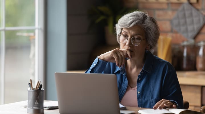 A woman sitting at a table with a laptop