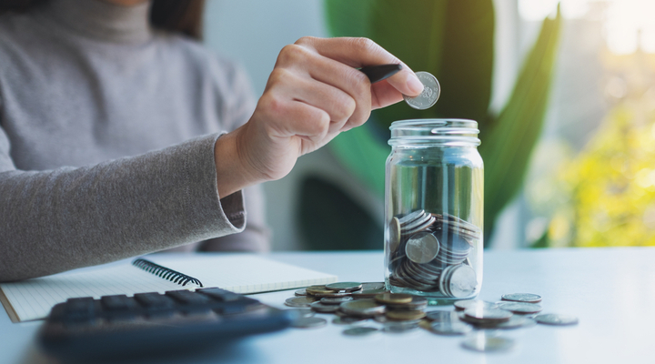 A child putting money in a jar.