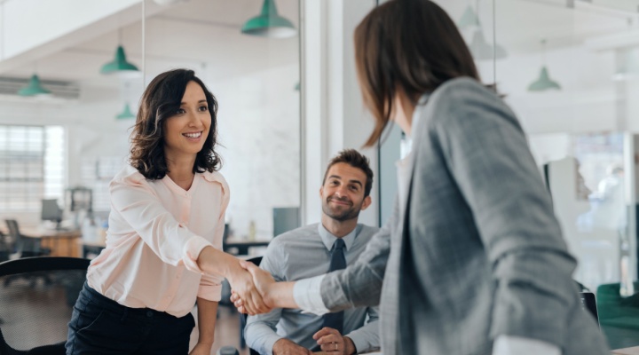 Two women shaking hands.