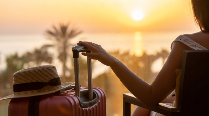 A woman sitting with a suitcase.