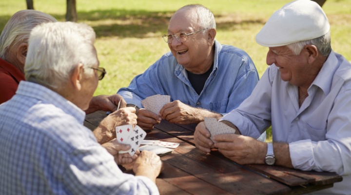 A group of friends playing cards outdoors.