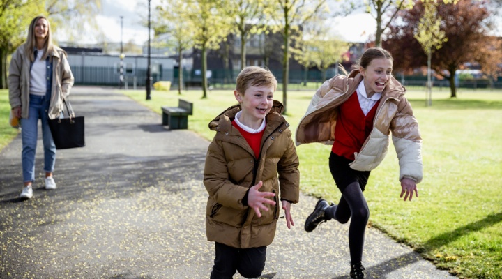 A mum and two children walking home from school.