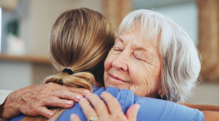 A senior woman hugging a caregiver.