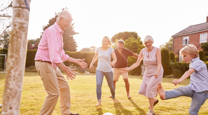 A family playing football in a garden.